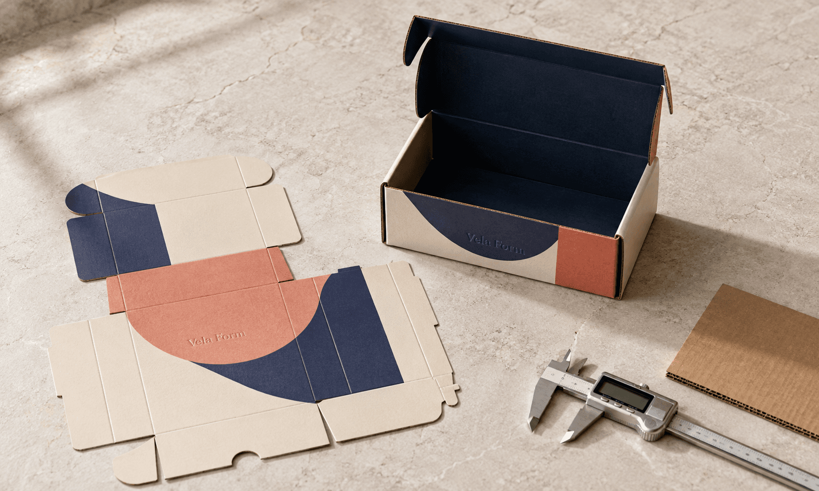Flat packaging dieline beside an assembled corrugated mailer box, calipers and printed production proof.